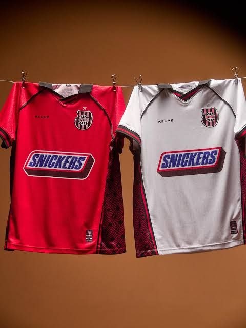 Manto vermelho (casa) e branco (visitante) da linha 2026 Brasil de Pelotas × Kelme, edição Snickers